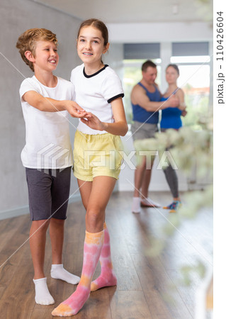 Active young children enjoying of partner dance in in dance studio during family class 110426604