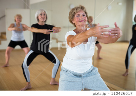 Mature women performing dance in exercise room Mature women performing dance in exercise room 110426617