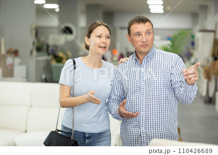 Spouses buyer looks around in showroom and chooses right fit furniture 110426689