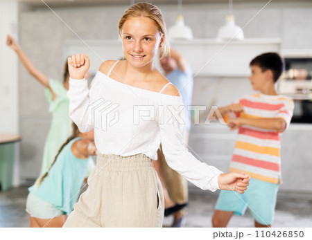 Behind cheerful girl, big family of parents, sisters, brother is rejoicing, dancing, having fun. 110426850