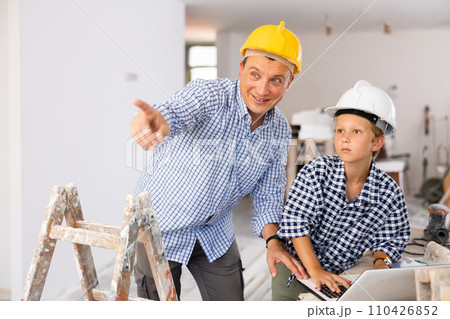 Young boy and his father discussing work plan in new apartment 110426852