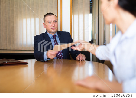 Business man and woman in office filling up documents 110426853