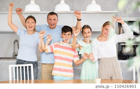 Big friendly family is rejoicing with happiness and raising their hands up they shout with happiness Big friendly family is rejoicing with happiness and raising their hands up they shout with happiness 110426901