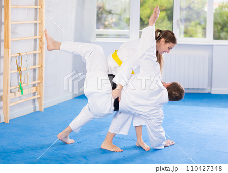 Adult man and young woman training judo fight Adult man and young woman training judo fight 110427348