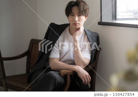 窓辺で考え事をする若い男性 窓辺で考え事をする若い男性 110427854