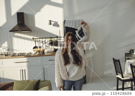 In her grasp, a lovely young woman holds a virtual reality headset. In her grasp, a lovely young woman holds a virtual reality headset. 110428689