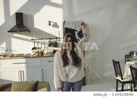 With grace, a beautiful young lady holds a virtual reality headset. With grace, a beautiful young lady holds a virtual reality headset. 110428690