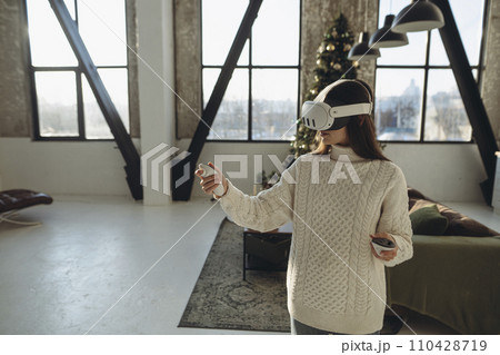 Describing her impressions, a beautiful girl in a VR headset shares her thoughts. Describing her impressions, a beautiful girl in a VR headset shares her thoughts. 110428719