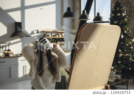 Amidst the sunny ambiance, a lively young woman wears a virtual reality headset. 110428753