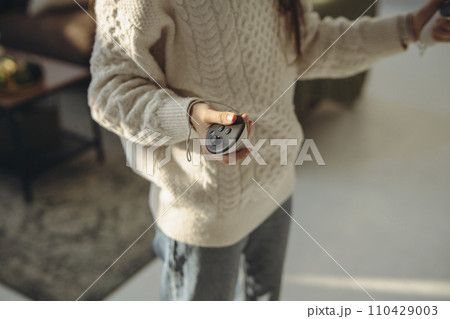 With sunlight streaming in, an active young woman explores virtual reality at home. 110429003
