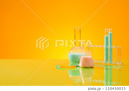Gradient yellow background featured a glass podium, test tubes and two flask of liquid. Glamour minimal pedestal for beauty, cosmetic product presentation 110430015