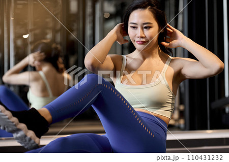 バイシクルクランチで腹筋を鍛える女性	 110431232