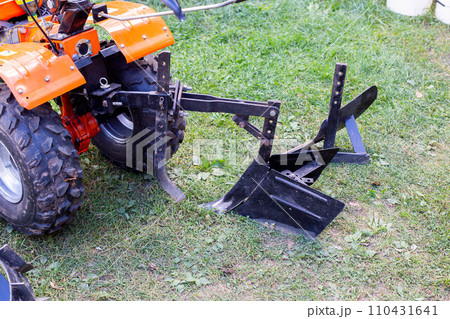 Plow and hiller complete with a walk-behind tractor for agricultural work. 110431641