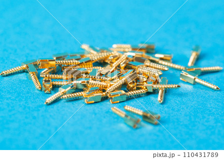 Lots of metal dental pins on a blue background. The concept of installing a tooth and a dental crown on pins in orthodontics, macro 110431789