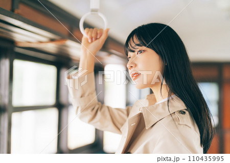 電車で吊り革を持つ女性 110435995