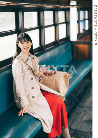 電車で音楽を聴く女性 110436152