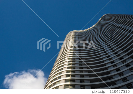 Curvilinear modern skyscrapers soar against a clear blue sky 110437530