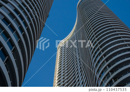 Curvilinear modern skyscrapers soar against a clear blue sky Curvilinear modern skyscrapers soar against a clear blue sky 110437535