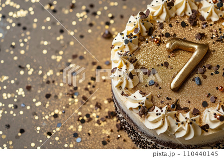 AI-generated content. Celebration cake with a glittering golden '7', perfect for a 7th birthday or anniversary. Shiny number seven. Bokeh lights, warm colors. Special event. Copy space for text 110440145