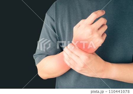 Man suffering from wrist hand pain over black background. Causes of hurt include carpal tunnel syndrome, fractures, arthritis or trigger finger. Health care concept. Copy space. 110441078