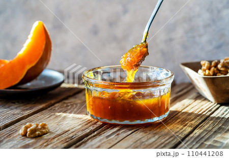 Autumn Harvest Pumpkin and walnuts Jam on wooden table, spoon with jam 110441208
