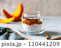 Spiced Pumpkin Chia Parfait in a glass with ingredients over grey background 110441209