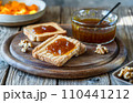 Rustic Pumpkin Jam Breakfast. Toasts with jam on wooden cutting board with jam jar 110441212