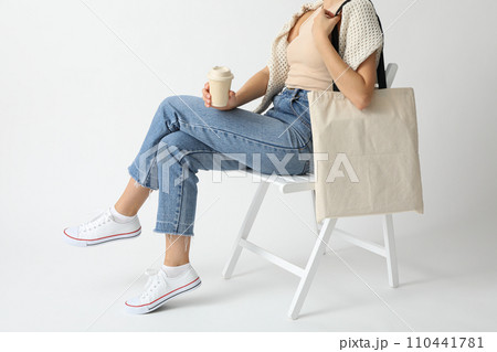 A woman is sitting on a chair with a bag in her hands 110441781