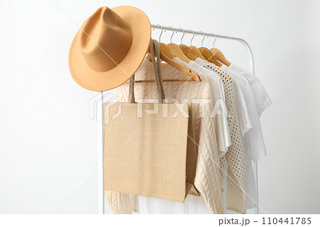 A bag hangs on a hanger with clothes A bag hangs on a hanger with clothes 110441785
