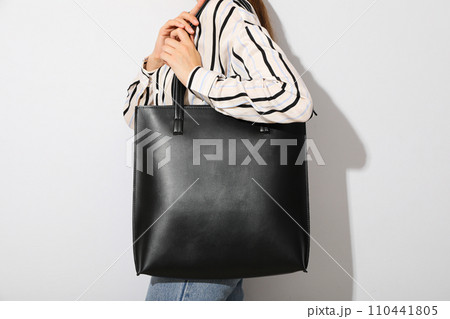 The woman has a black bag on her shoulder The woman has a black bag on her shoulder 110441805