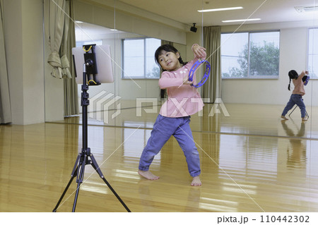 タブレットを見ながらダンスする小学生の女の子　撮影協力:有明教育芸術短期大学 110442302