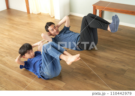 並んでストレッチをする小学生と大人の男性 並んでストレッチをする小学生と大人の男性 110442979
