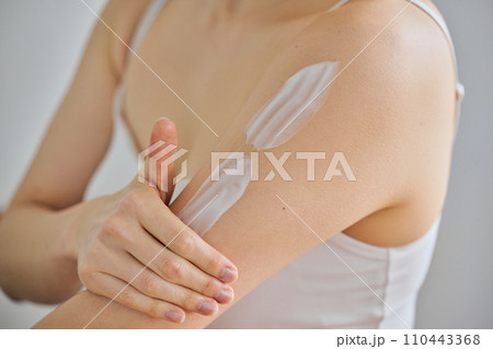 二の腕にクリームを塗ってボディケアする30代女性 二の腕にクリームを塗ってボディケアする30代女性 110443368