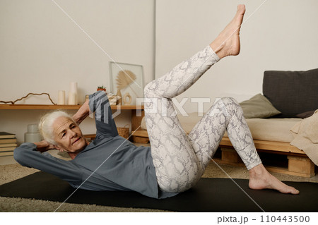 Woman doing physical exercise on mat 110443500