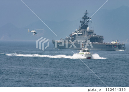 海上自衛隊護衛艦の横を通過する海上保安庁の巡視艇とヘリコプター 海上自衛隊護衛艦の横を通過する海上保安庁の巡視艇とヘリコプター 110444356