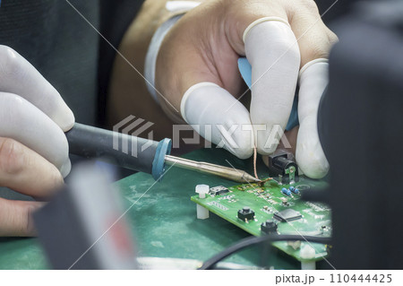 Close up scene the soldering operation by skill operator with rubber finger cot. Close up scene the soldering operation by skill operator with rubber finger cot. 110444425