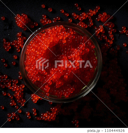 Red caviar, a jar with fresh appetizing, tasty caviar on a black background, top view, flatley, for advertising and design of fish stores 110444926
