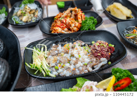 Korean food. Sliced raw beef and live octopus Korean food. Sliced raw beef and live octopus 110445172