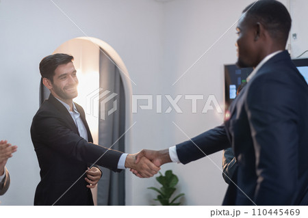 Businessmen shake hands and congratulate each other in the conference room. 110445469