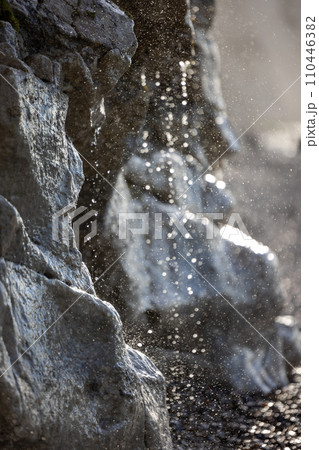 Elemental Dance: Sunlit Waterfall on the Cliffside 110446382