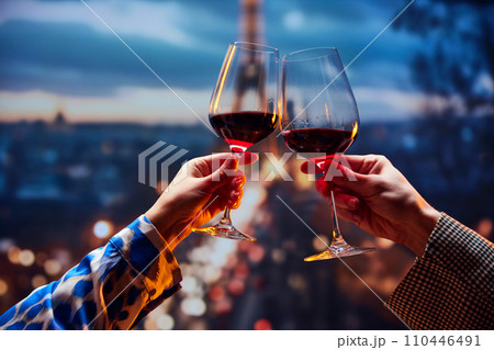 Beloved couple sitting at sunset and drinking wine in front of the main attraction in France. Honeymoon for newlyweds. Tourism and relax. Beloved couple sitting at sunset and drinking wine in front of the main attraction in France. Honeymoon for newlyweds. Tourism and relax. 110446491