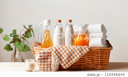 AI-generated content. Various detergents for washing and cleaning, colored towels in wicker basket, on light tabletop with green plants 110446844