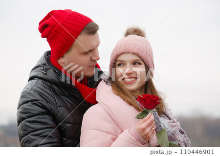 A man gives a red rose to a young woman A man gives a red rose to a young woman 110446901