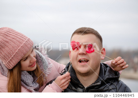 Young beautiful woman with red sweets on a stick in hands Young beautiful woman with red sweets on a stick in hands 110446945