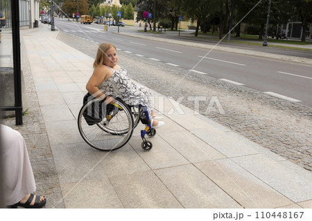 International Wheelchair Day. Person With Short Stature On Wheelchair Waiting For Public Transport On Bus Stop Outdoor. Female Adult With Disability. Copy Space For Text. Transportation. International Wheelchair Day. Person With Short Stature On Wheelchair Waiting For Public Transport On Bus Stop Outdoor. Female Adult With Disability. Copy Space For Text. Transportation. 110448167