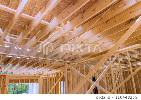During construction of new unfinished residential home, wood framing supports beam 110448255