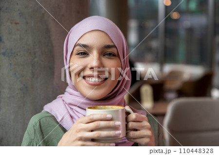 Young woman with a cup of coffee looking romantic and dreamy 110448328
