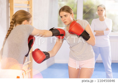 Teen girls in punch mitts boxing Teen girls in punch mitts boxing 110450846