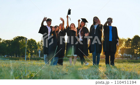 Student alumni waving at sunset. 110451194