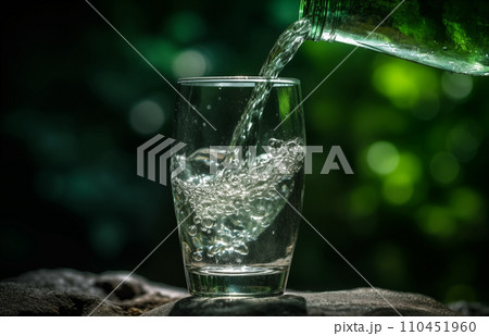 Drink water pouring in to glass mug from water plastic bottle on green background. Drink water pouring in to glass mug from water plastic bottle on green background. 110451960